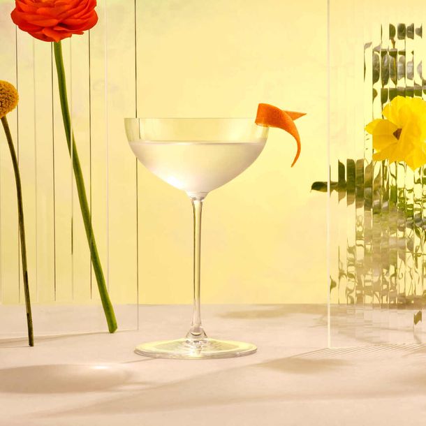An Aviation Cocktail served in an elegant martini glass and served with a twirled citrus peel.