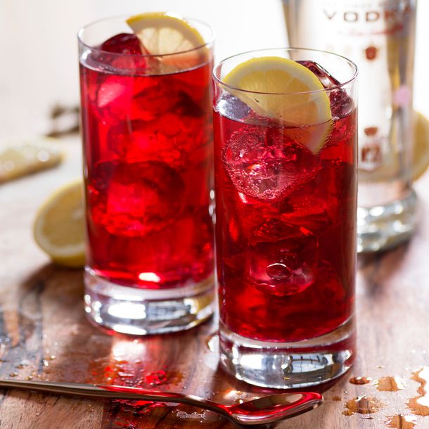 A deep red Sea Breeze cocktail served in a tall glass with a citrus slice