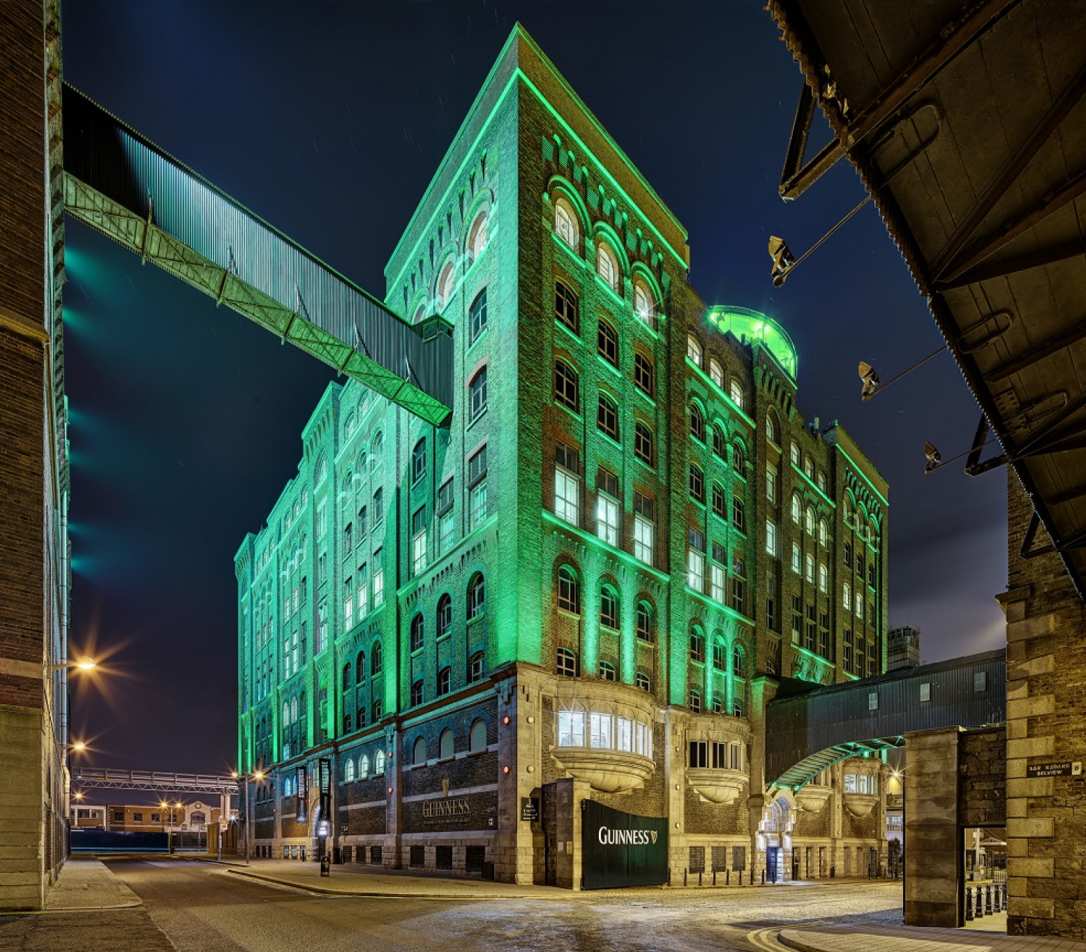 Outside view of Guinness Storehouse building with green lighting