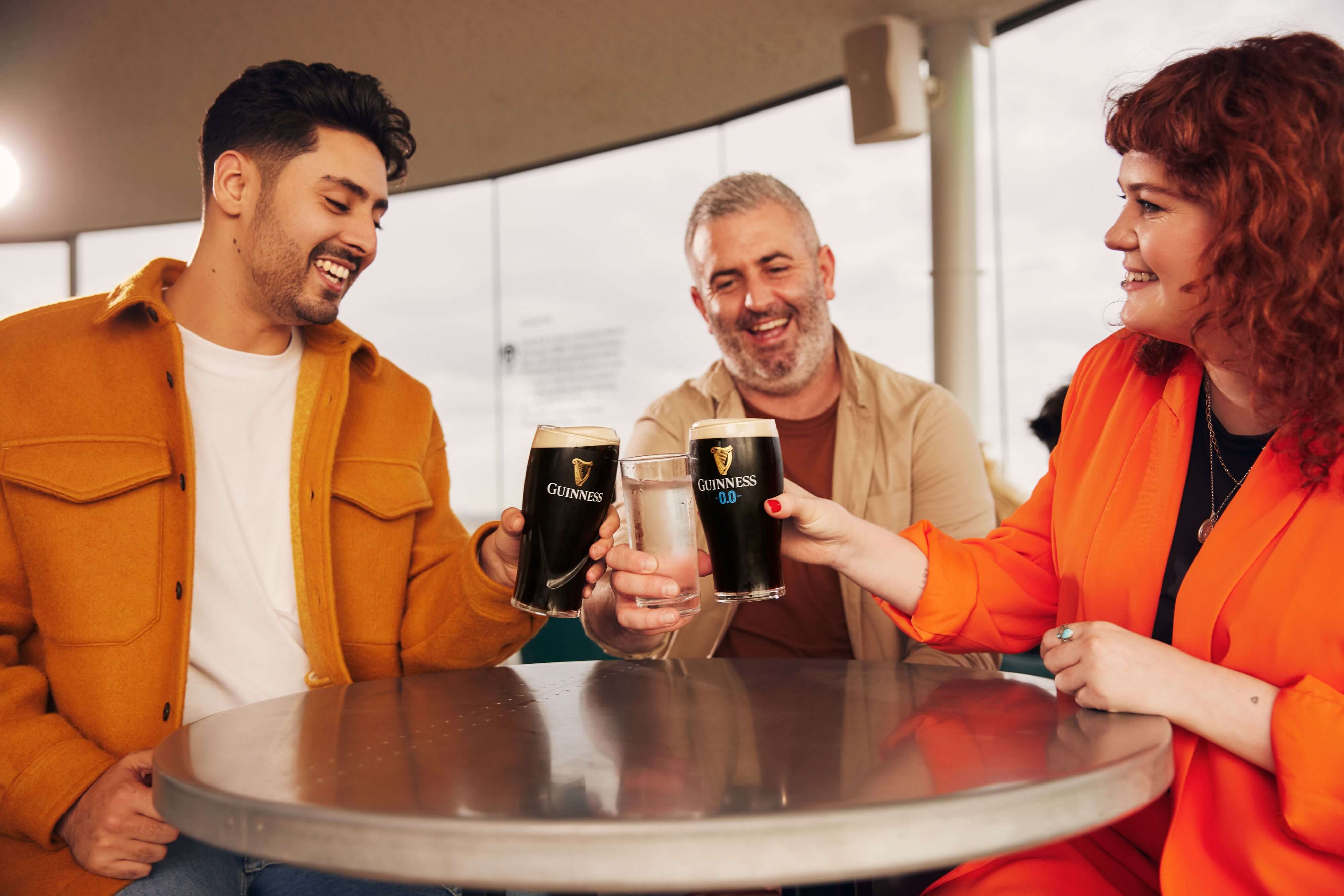 Happy visitors toasting with pint of Guinness at the Gravity Bar