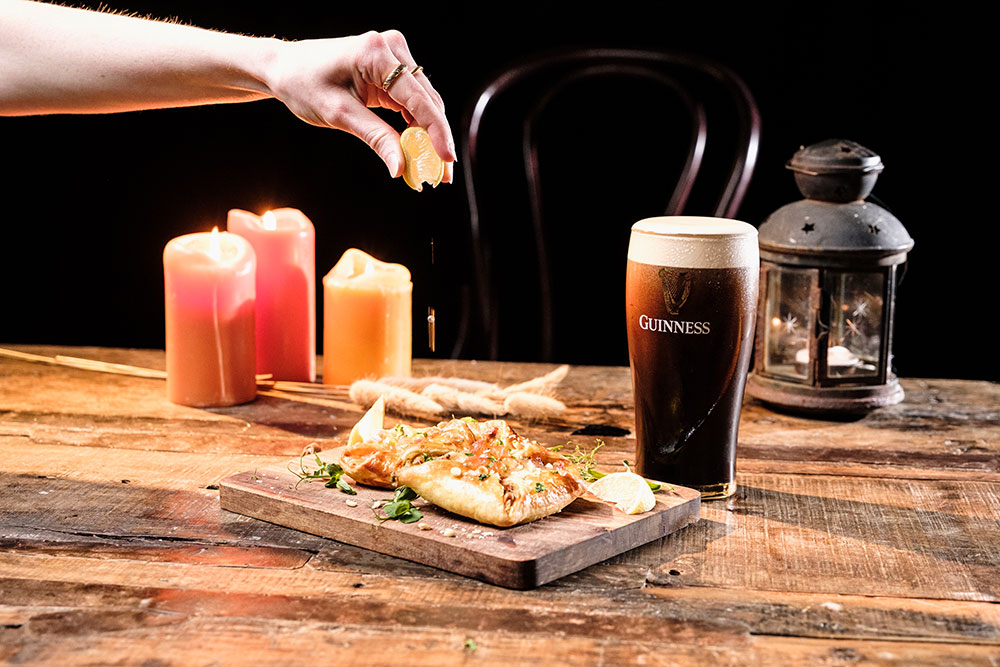 A Guinness cured salmon jambon with a pint of Guinness beside it