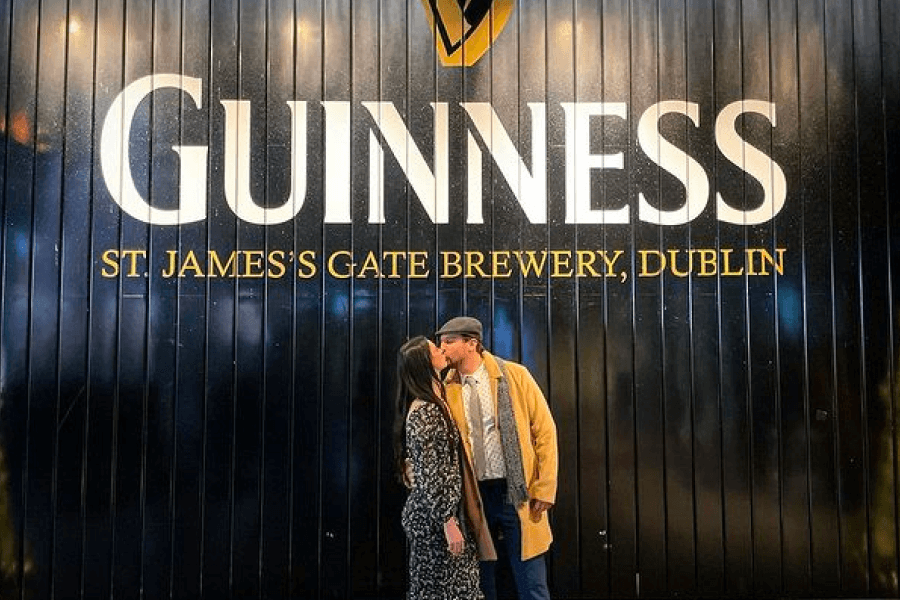 Couple romantically kissing in front of the famous Guinness Gate