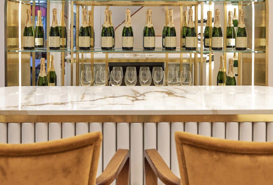 bar with shelf of champagnes behind 