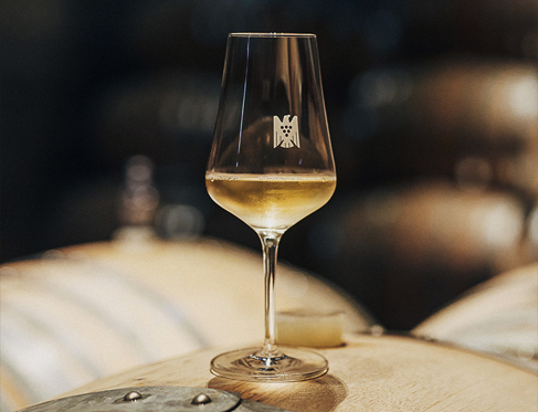 A glass of Riesling wine on top of a barrel
