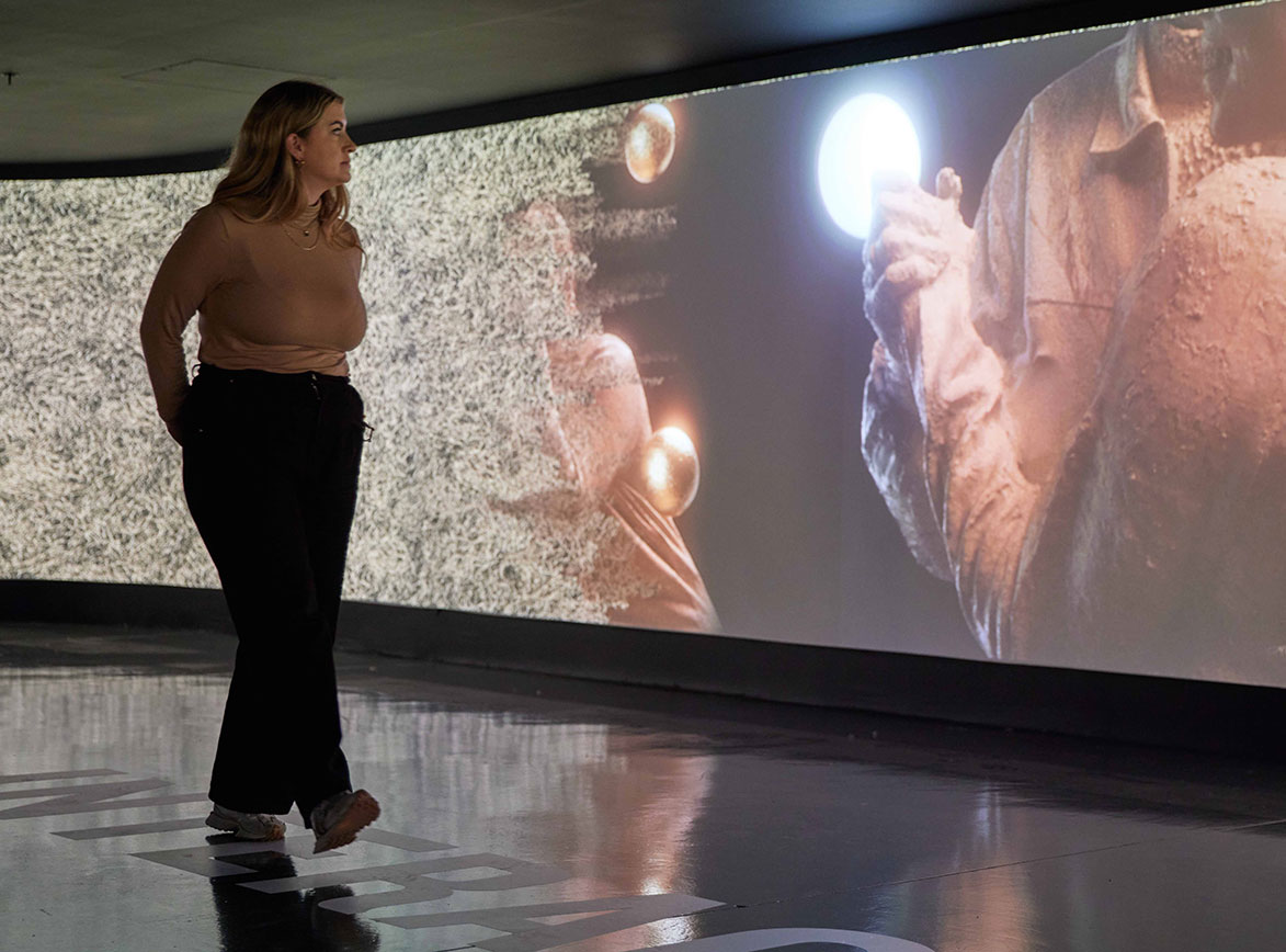 A woman walks by an interactive installation in a cinema room