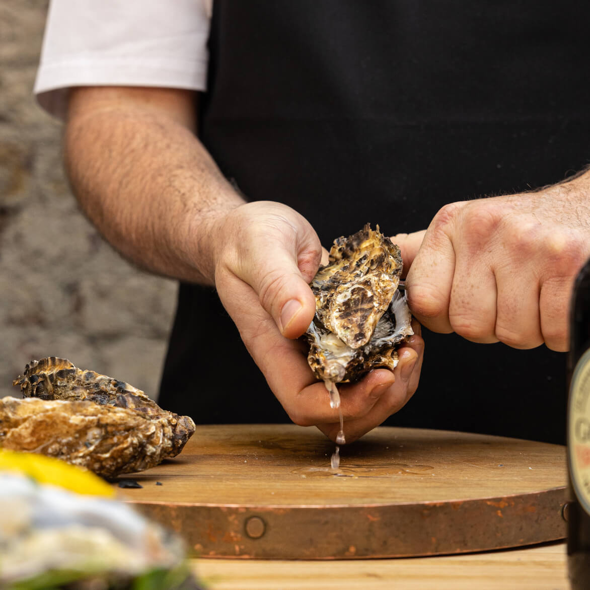 Chef cutting open the oysters used for Brewers’ Dining Hall menu.