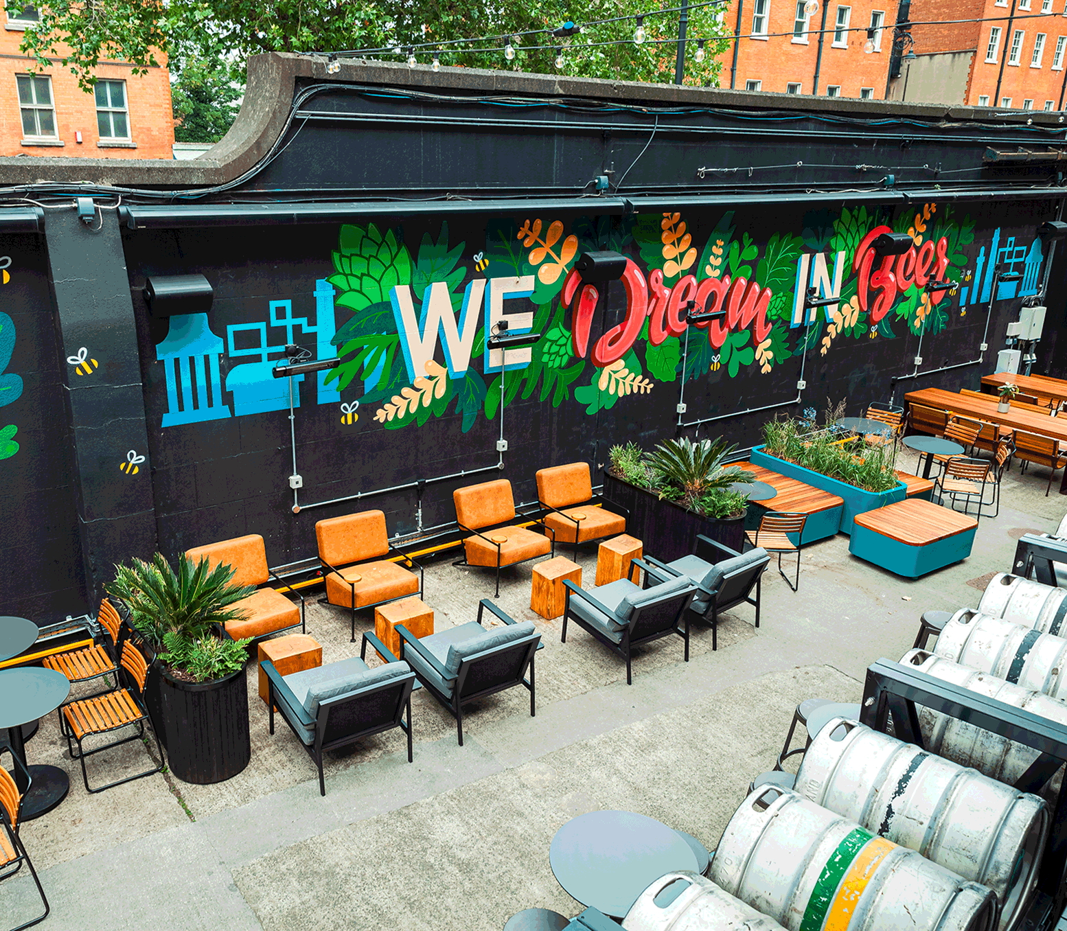Guinness Open Gate Brewery exterior view showing tables and chairs and a mural that says 'we dream in beer'