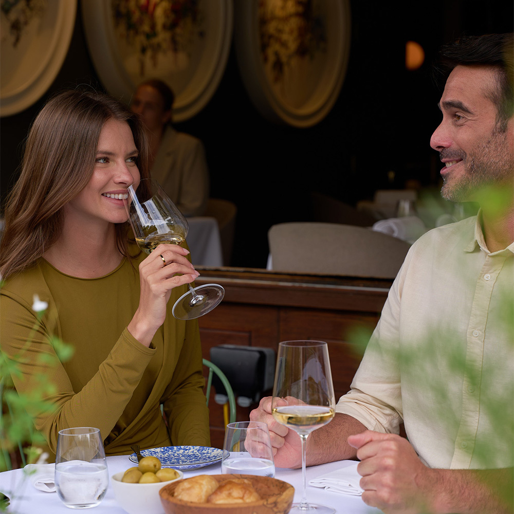 A couple having lunch and the lady drinking a white wine