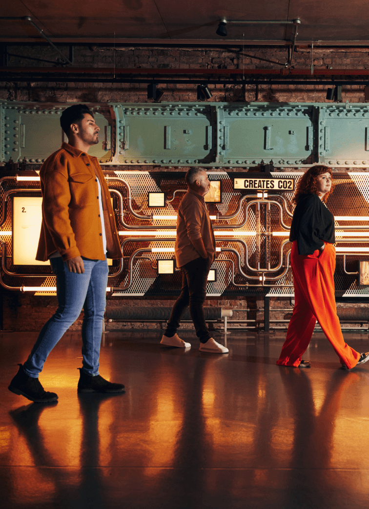 Three visitors walking around the first floor of Guinness Storehouse 