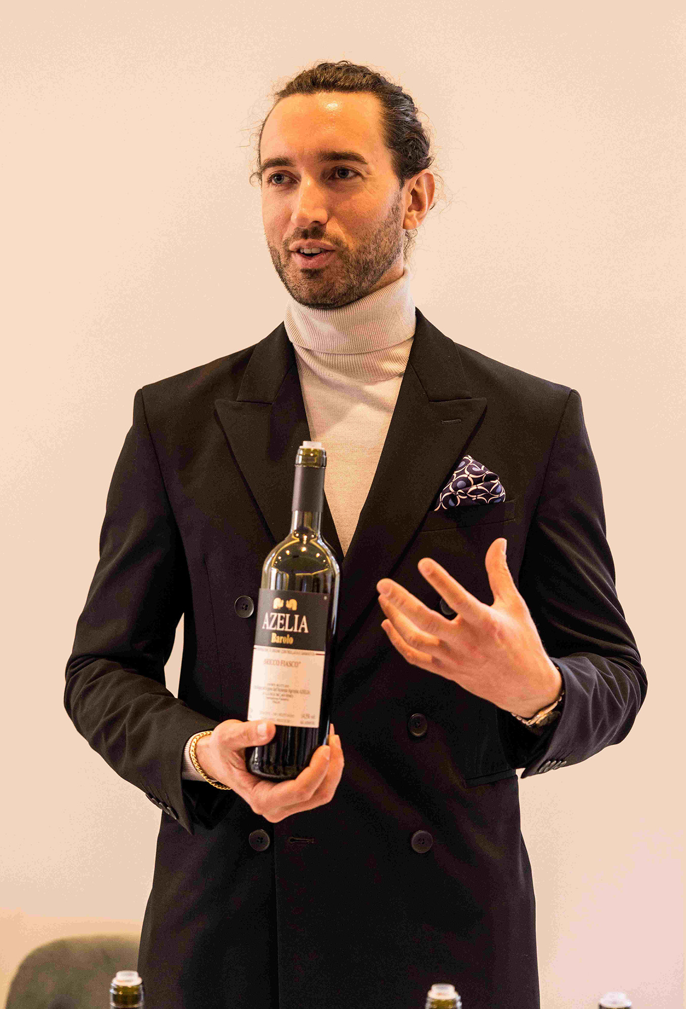 man holding bottle of wine in suit