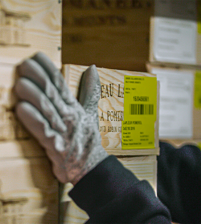 A person placing their hands on a box of wine