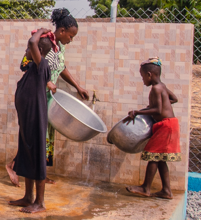 African woman and two kids filling up buckets with water