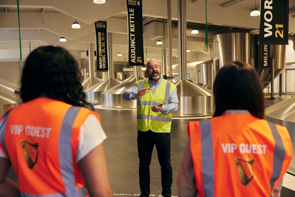 Tour guide explaining to visitors how Guinness in produced