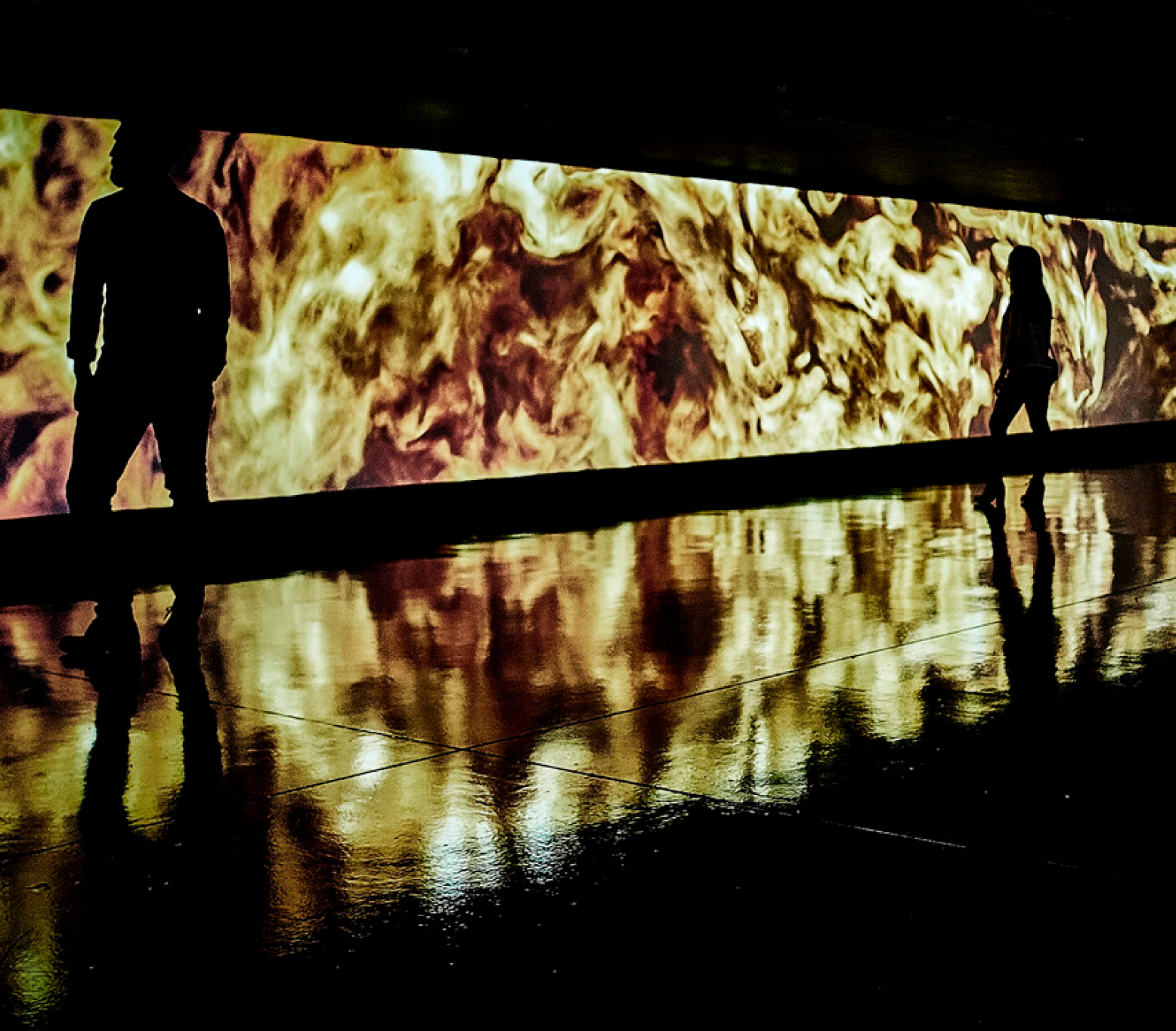 People silhouette in front of large cinema screen