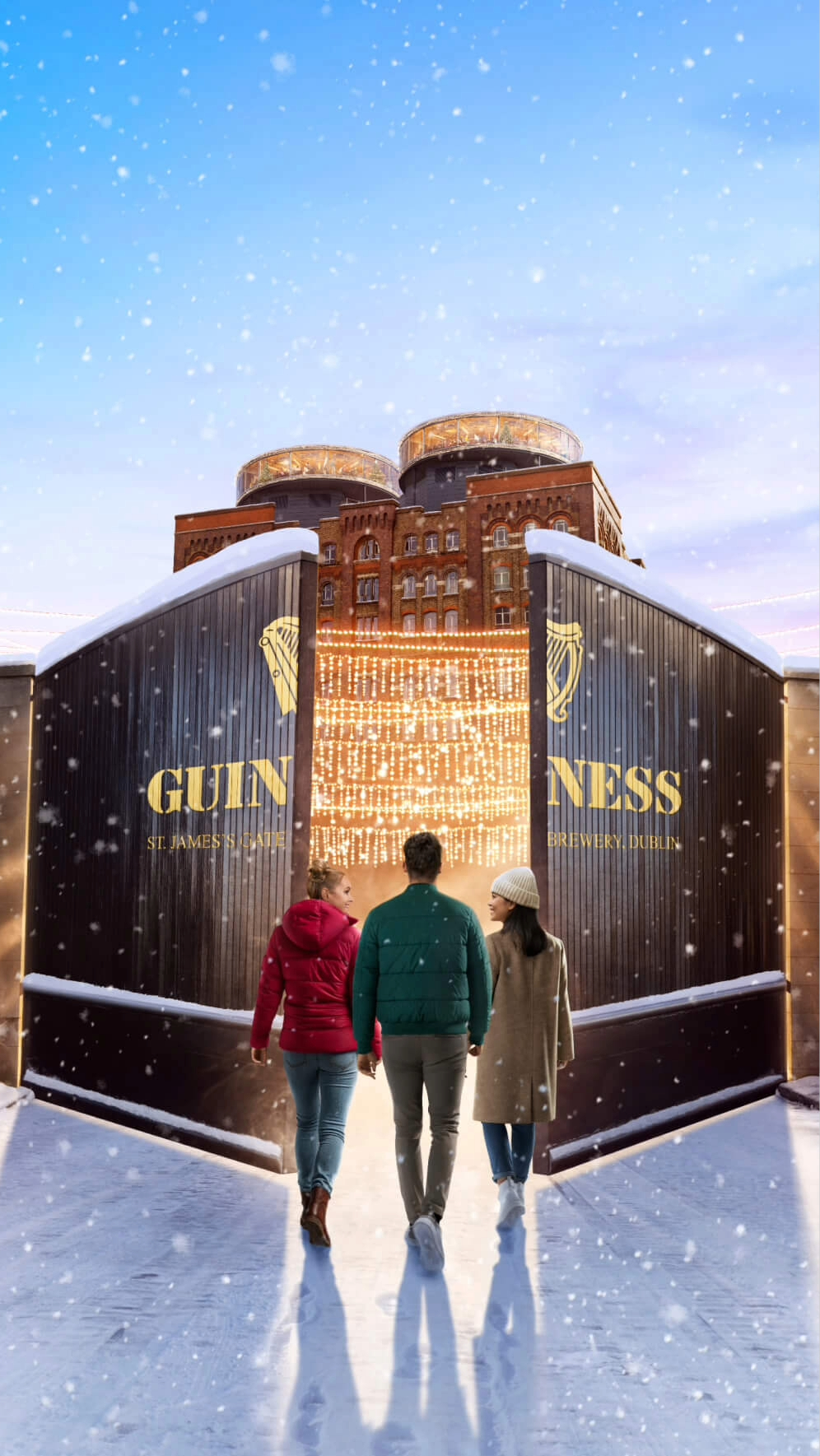 A group of three people entering the Guinness Storehouse's main gate with a sight of the building decorated in Christmas decoration