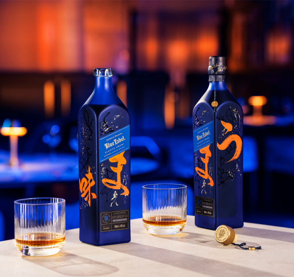 Two bottles with glasses on table with orange and blue lights