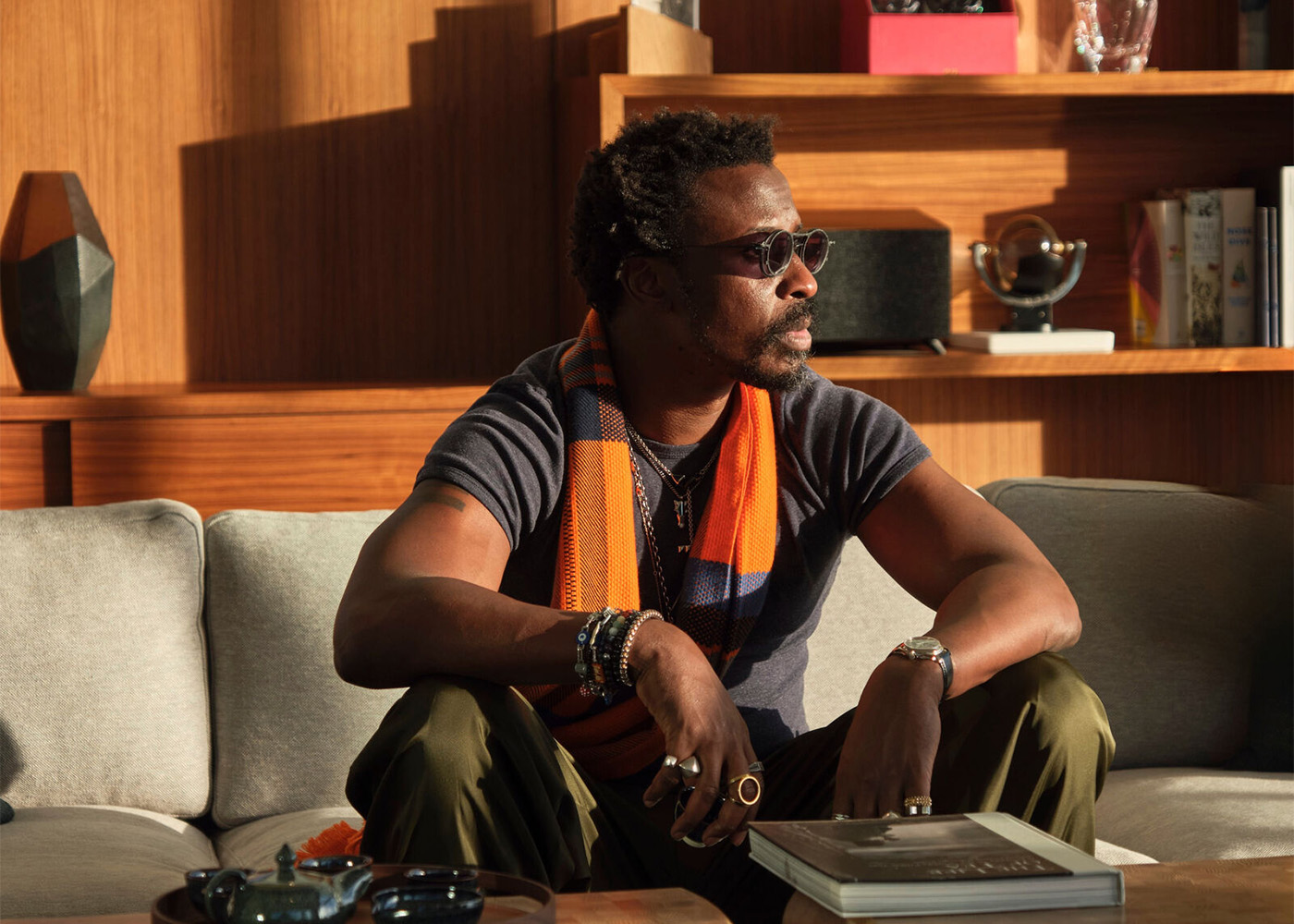 Ini Archibong in a room sitting on a couch looking out the window