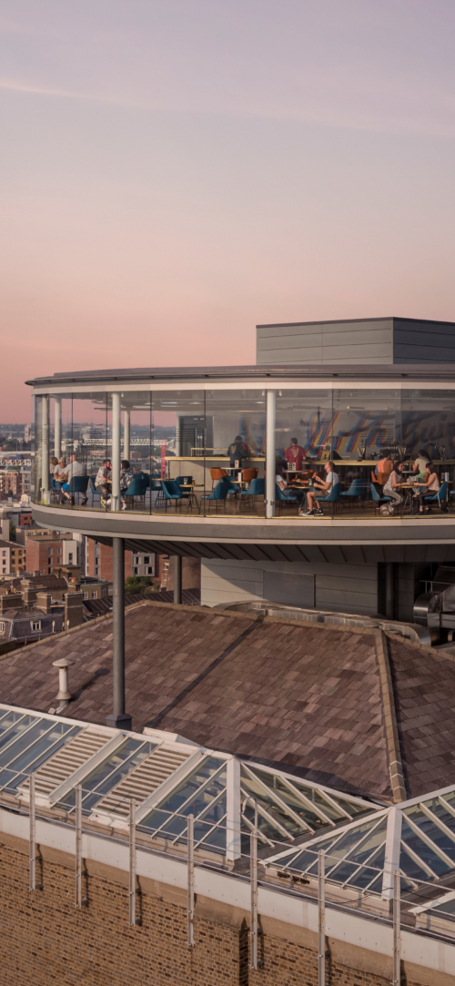 An aerial view of the Gravity bar at sunset, with people sitting in it enjoying a pint of Guinness 