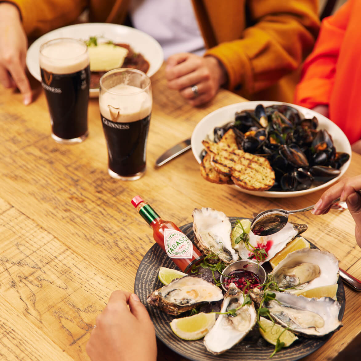 A group of friends enjoying their lunch at Brewers’ Dining Hall with oysters and mussels paired with Guinness Draught.