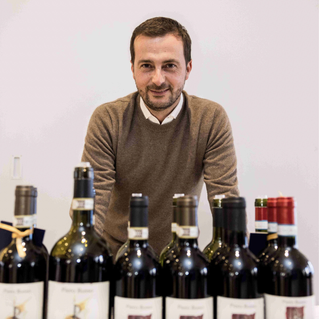piero busso behind a row of wines