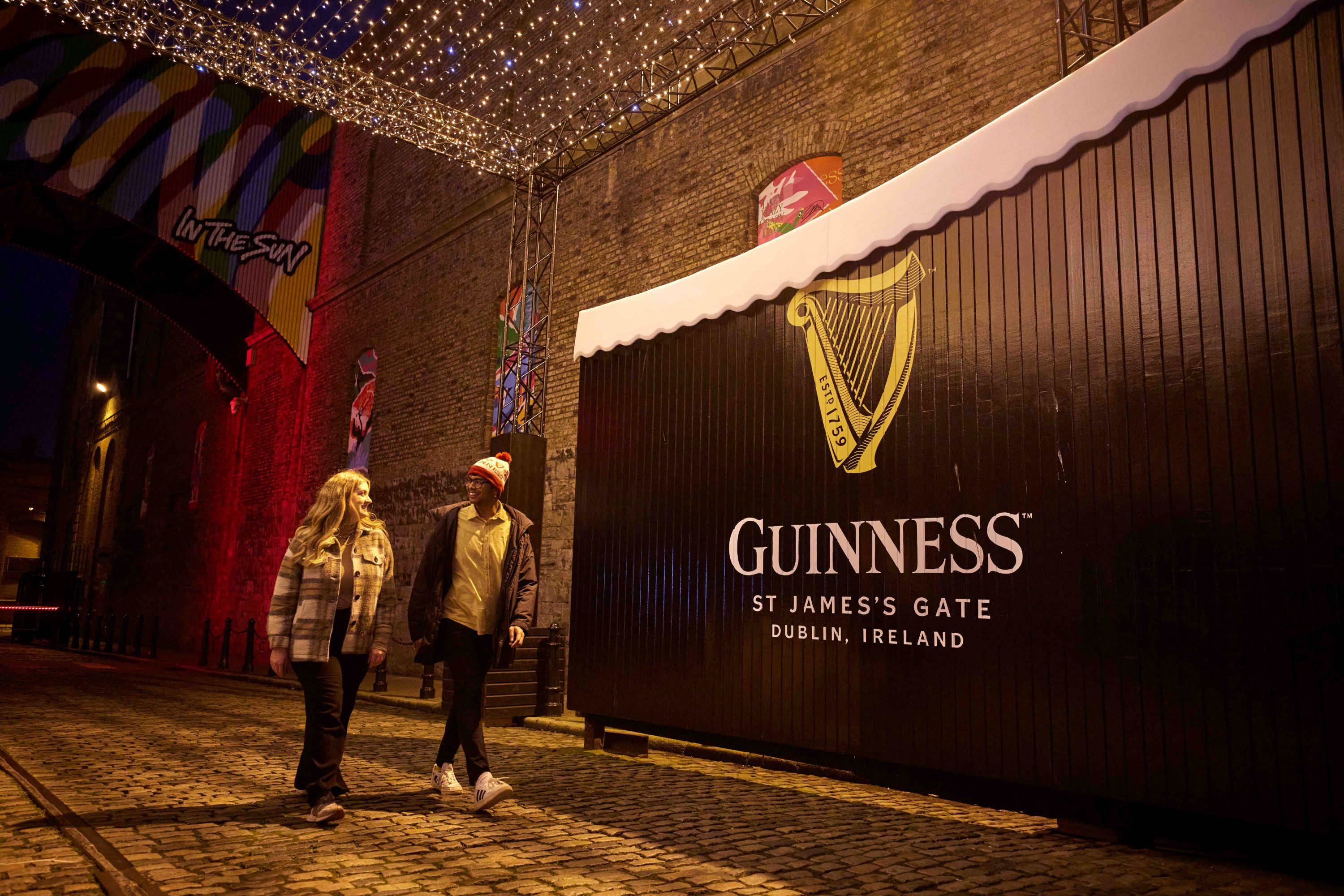 Couple walking in front of iconic Dublin gates during winter